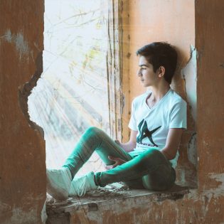 Photo by mohammad hosein MOSAYEBI: https://www.pexels.com/photo/boy-sitting-near-wall-940585/